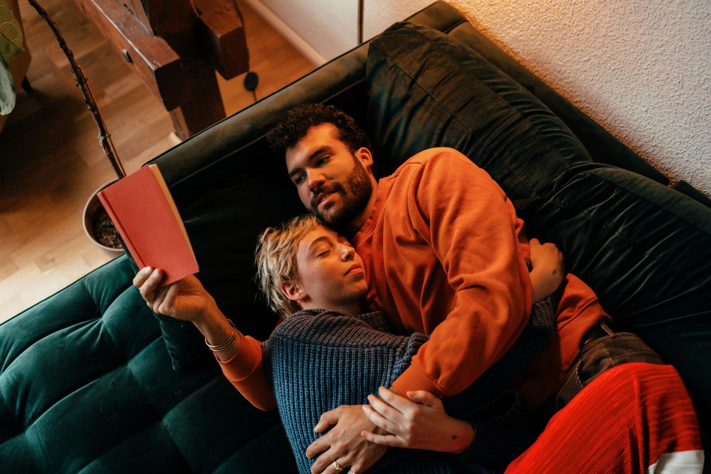 ein Paar liegt auf der Couch und kuschelt
