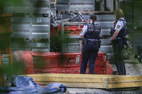 Zwei Polizistinnen stehen neben einer abgestürzten Kran-Gondel in Horb am Neckar (Baden-Württemberg)