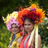 Zwei Junge Frauen beim Royal Ascot mit bunten Hüten aus Blumen und Schmetterlingen