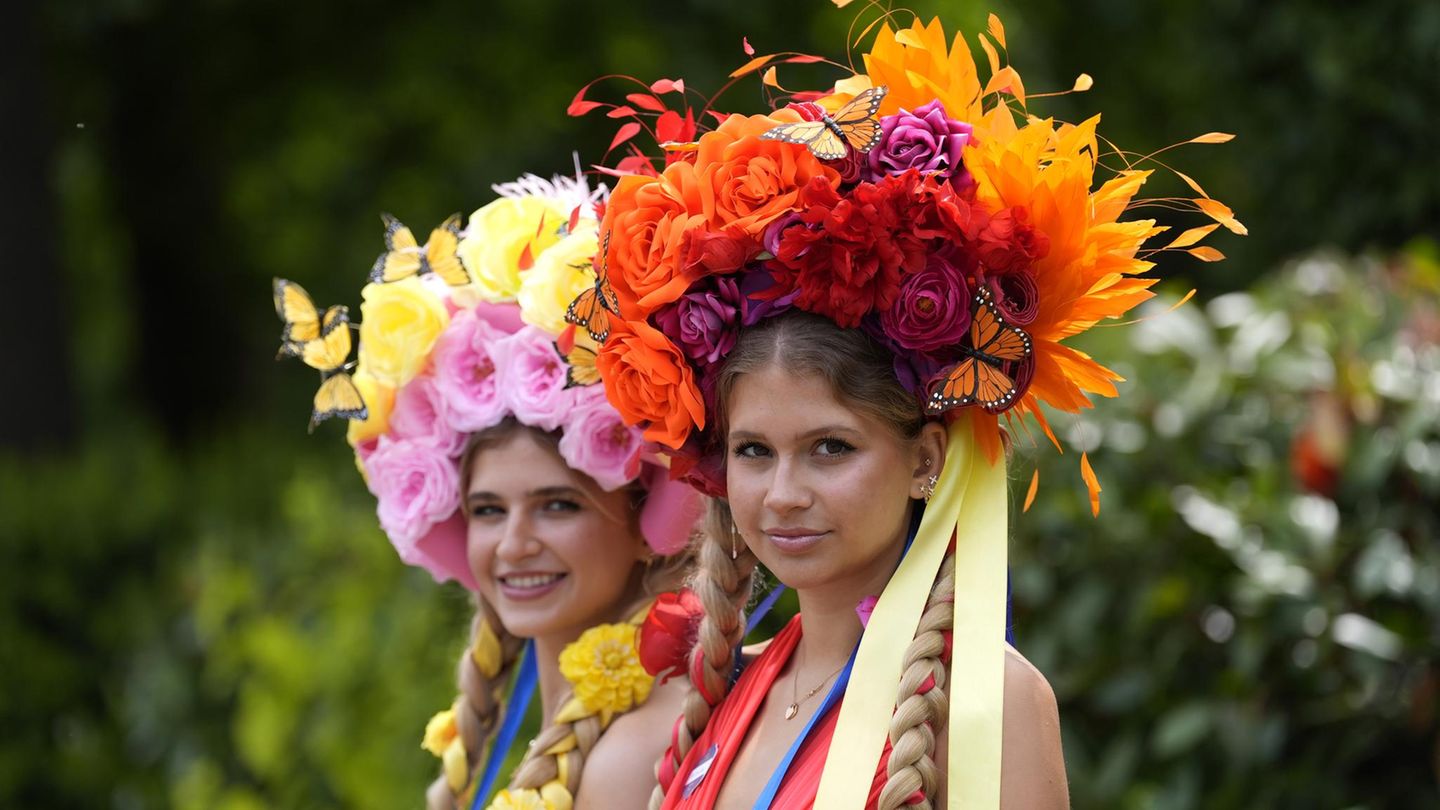 Zwei Junge Frauen beim Royal Ascot mit bunten Hüten aus Blumen und Schmetterlingen