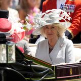 Camilla in der Kutsche zum Royal Ascot. Sie trägt einen grauen Blazer und einen grauen Hut mit Federn
