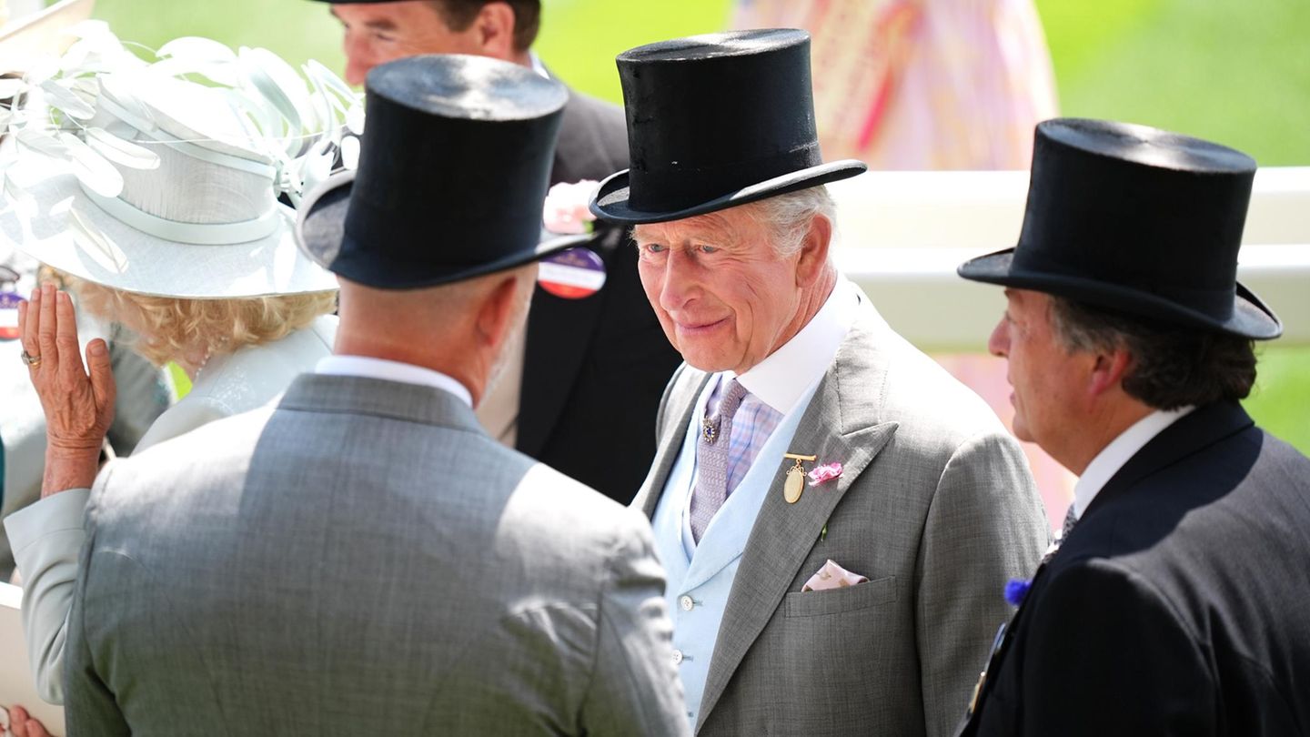 King Charles im Gespräch beim Royal Ascot. Er trägt einen grauen Anzug