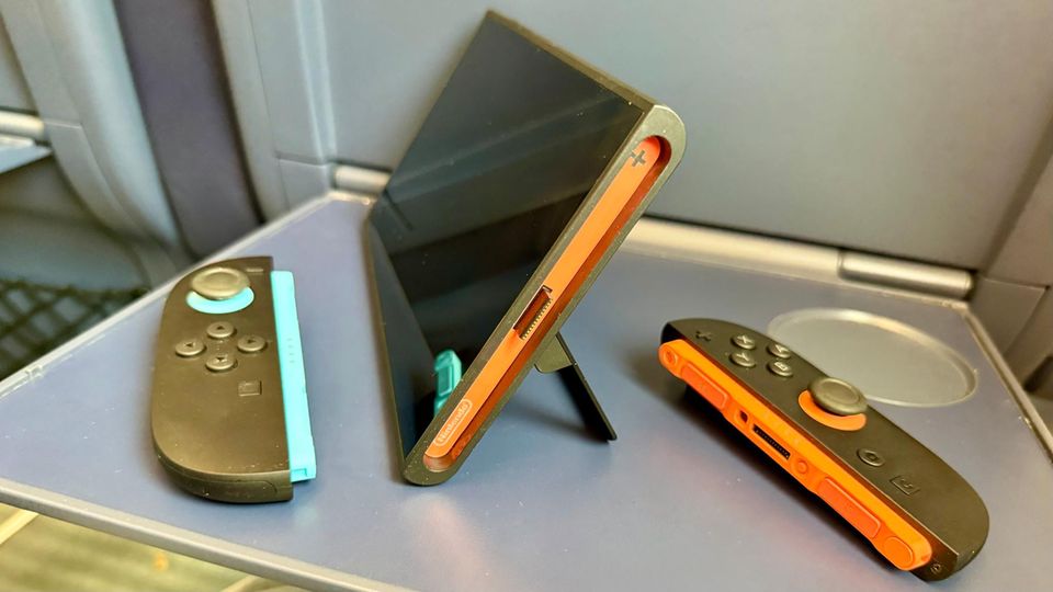 Die Nintendo Siwtch 2 steht auf einem Zug-Ausklapptisch Die Nintendo Siwtch 2 steht auf einem Zug-Ausklapptisch