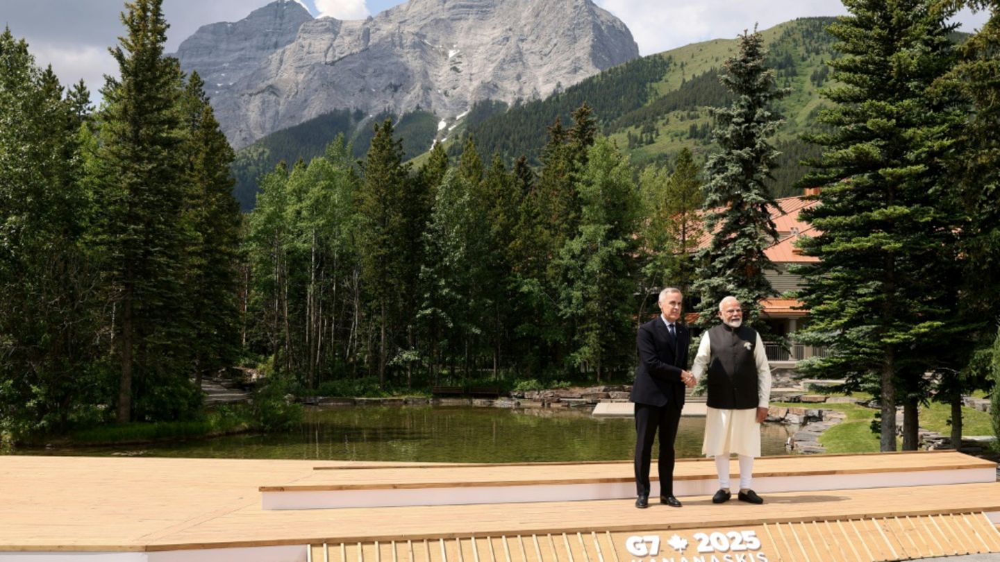 Canadian Prime Minister Mark Carney greets Indian Prime Minister Narendra Modi before a group photo during the Group of Seven su