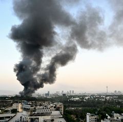 Nach einem israelischen Luftangriff auf den Sitz des iranischen Staatsfernsehens steigt schwarzer Rauch in den Himmel über Teheran