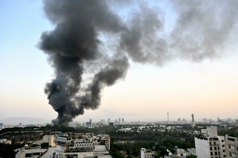 Nach einem israelischen Luftangriff auf den Sitz des iranischen Staatsfernsehens steigt schwarzer Rauch in den Himmel über Teheran