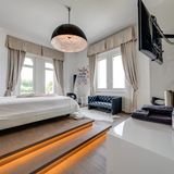 Das Bett im Schlafzimmer thront auf einer Art Podest