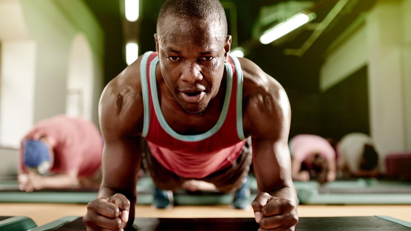 Beckenboden: ein Mann macht Planks im Gym