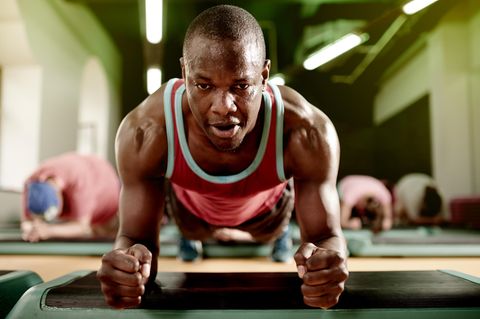 Beckenboden: ein Mann macht Planks im Gym