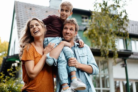 Familie spielt nach dem Hauskauf im eigenen Garten
