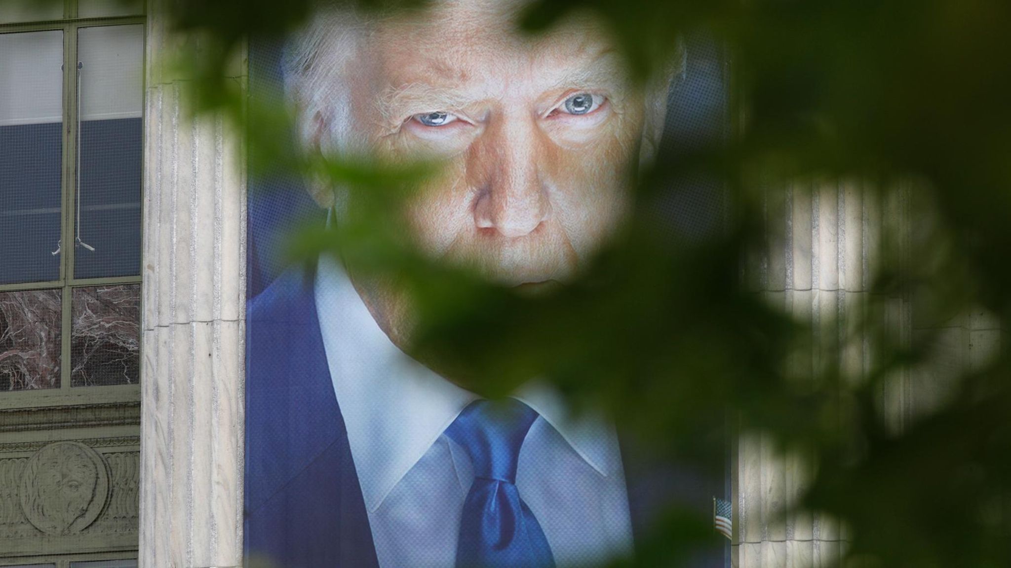 Donald Trump-Plakat durch einen Baum hindurch fotografiert