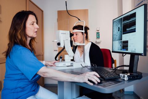 Ärztin und Patientin beim Sehtest vor einem Bildschirm