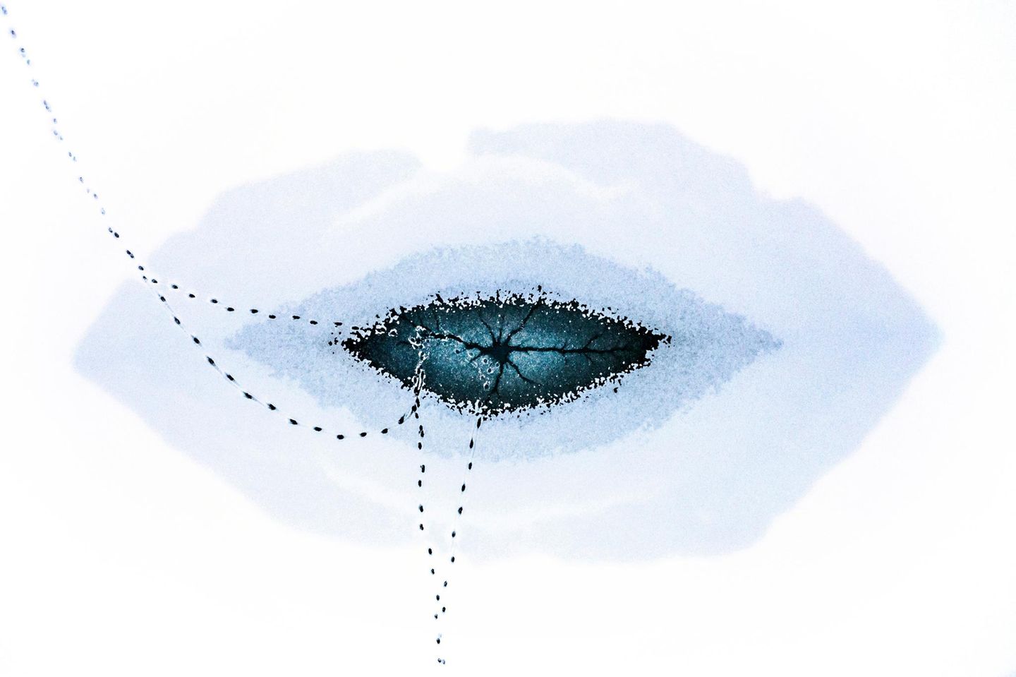 Ein Auge im Eissee Riss in eingefrorenem See von oben