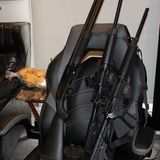 Eine gute Handvoll Gewehre, aneinandergereiht auf Bürostühlen und Gaming-Sesseln