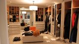 Eines der Ankleidezimmer war nach der Durchsuchung verwüstet – Taschen, Kisten und Dokumente blieben teils offen stehen. Und mittendrin: ein riesiger Plüschteddy