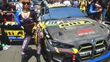 Ein Grid-Girl schmückt den BMW M4 GT4 mit der Startnummer 146 vom Team Giti Tire Motorsport in der Startaufstellung.