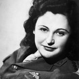 Porträtfoto einer Frau in Uniform mit offenen dunklen Haaren, schwarz-weiß, 1945