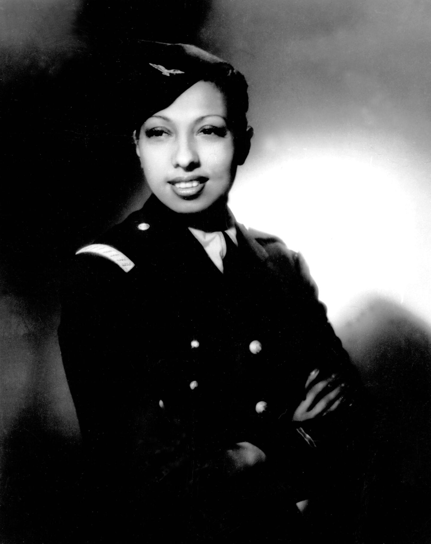Josephine Baker (1906–1975) – Die Tänzerin mit dem Pilotenschein Porträtfoto einer Frau in Uniform, mit Schiffchen auf dem Kopf, die Arme vor der Brust verschränkt