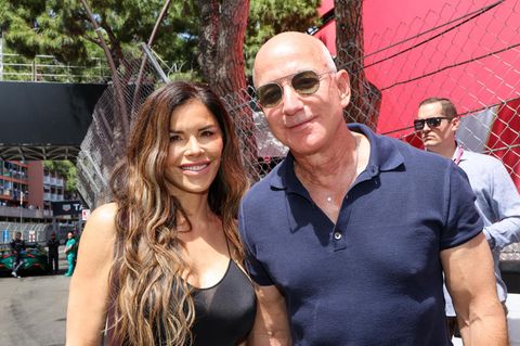 Jeff Bezos und Lauren Sanchez blicken in die Kamera. Er trägt eine Sonnenbrille