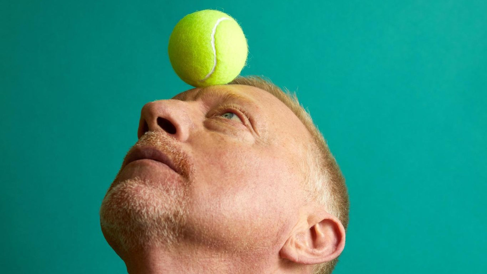 Boris Becker balanciert einen Tennisball auf der Stirn
