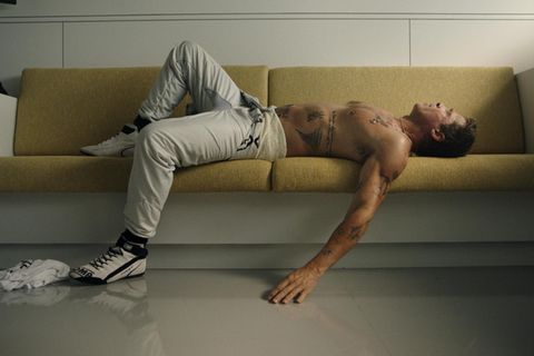 Oldtimer mit Tattoos: Szene aus "F1" mit Sonny Hayes (Brad Pitt), erschöpft nach einem Formel-1-Rennen