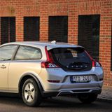 Der Vovlo C30 steht vor einem Backsteingebäude und zeigt sein Heck