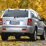 Der Jeep Grand Cherokee fährt über eine Straße mit viel Laub