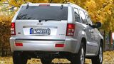 Der Jeep Grand Cherokee fährt über eine Straße mit viel Laub