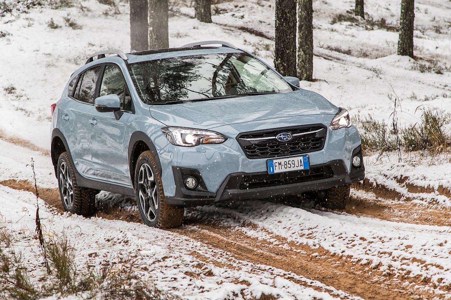 Der Subaru XV fährt über einen verschneiten Waldweg Der Subaru XV fährt über einen verschneiten Waldweg