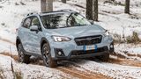 Der Subaru XV fährt über einen verschneiten Waldweg