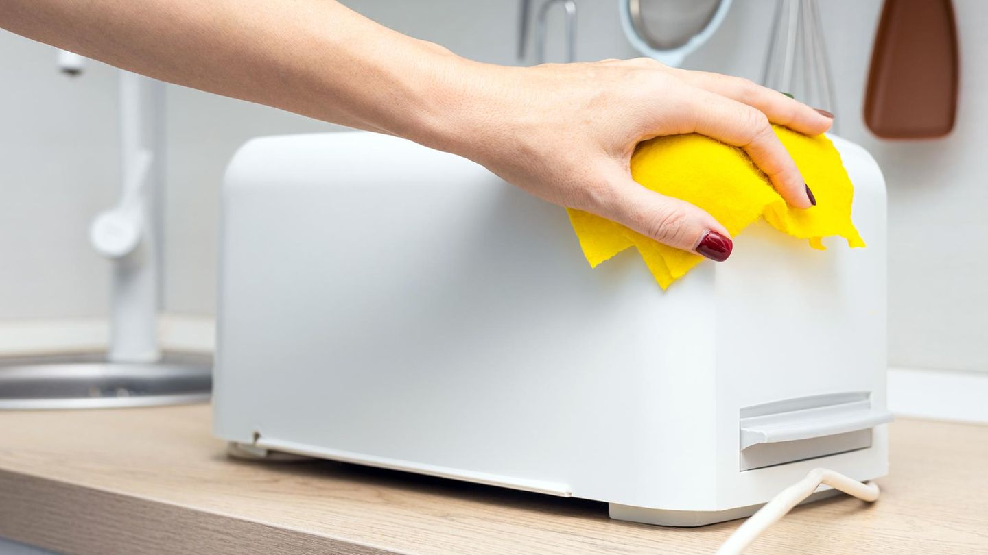 Person beim Toaster-Reinigen