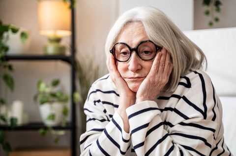 Symbolfoto für Single: Eine Frau sitzt alleine in einem Wohnzimmer