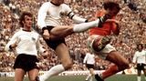 Franz Beckenbauer wie er in der Luft den Ball kickt, 1974
