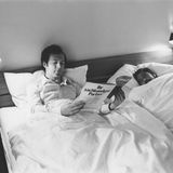 Beckenbauer und Gerd Müller liegen in einem Doppelbett, Beckenbauer liest ein Magazin