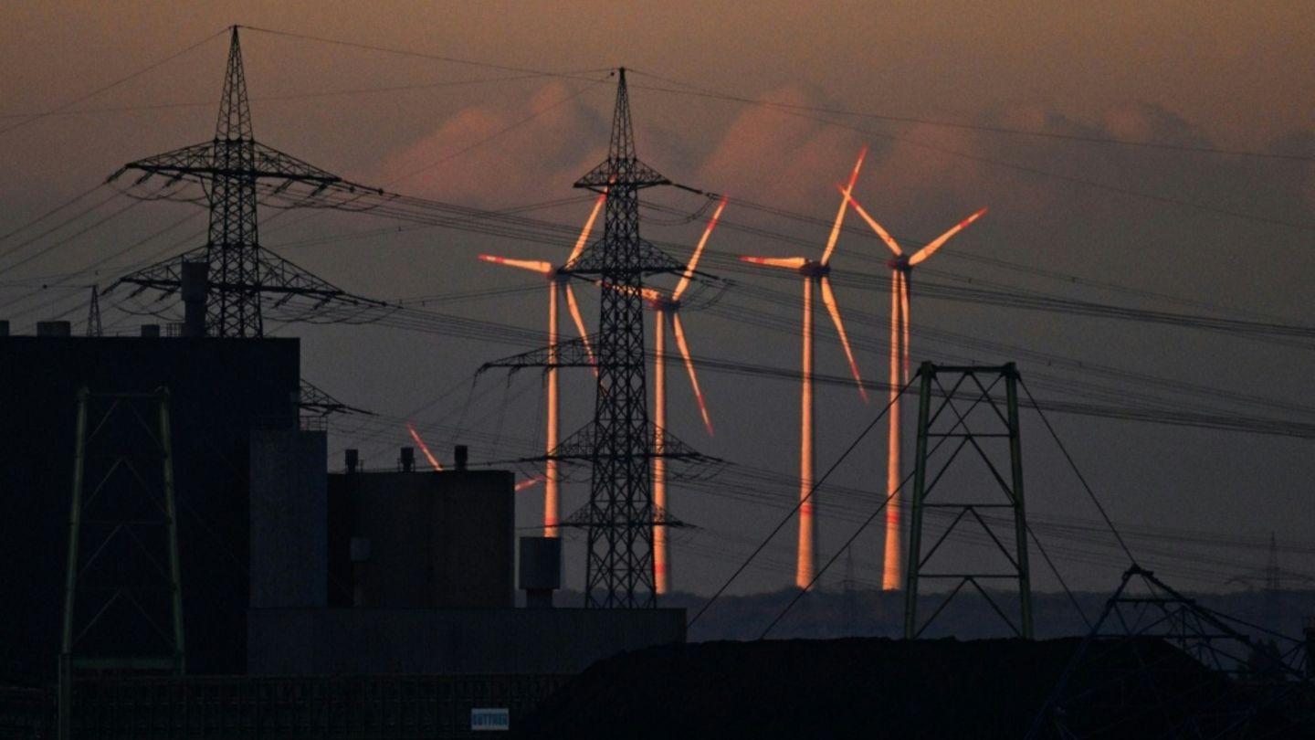 Windkraftanlagen neben Strommasten
