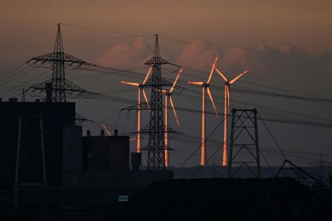 Windkraftanlagen neben Strommasten