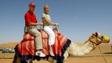 Franz Beckebauer und Ehefrau Heidi im Urlaub auf einem Kamel sitzend