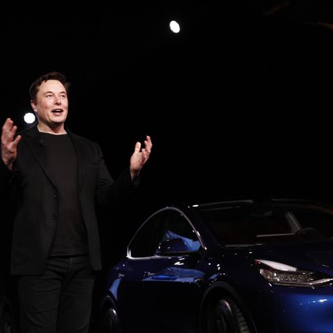 Elon Musk steht vor einem Tesla Model Y
