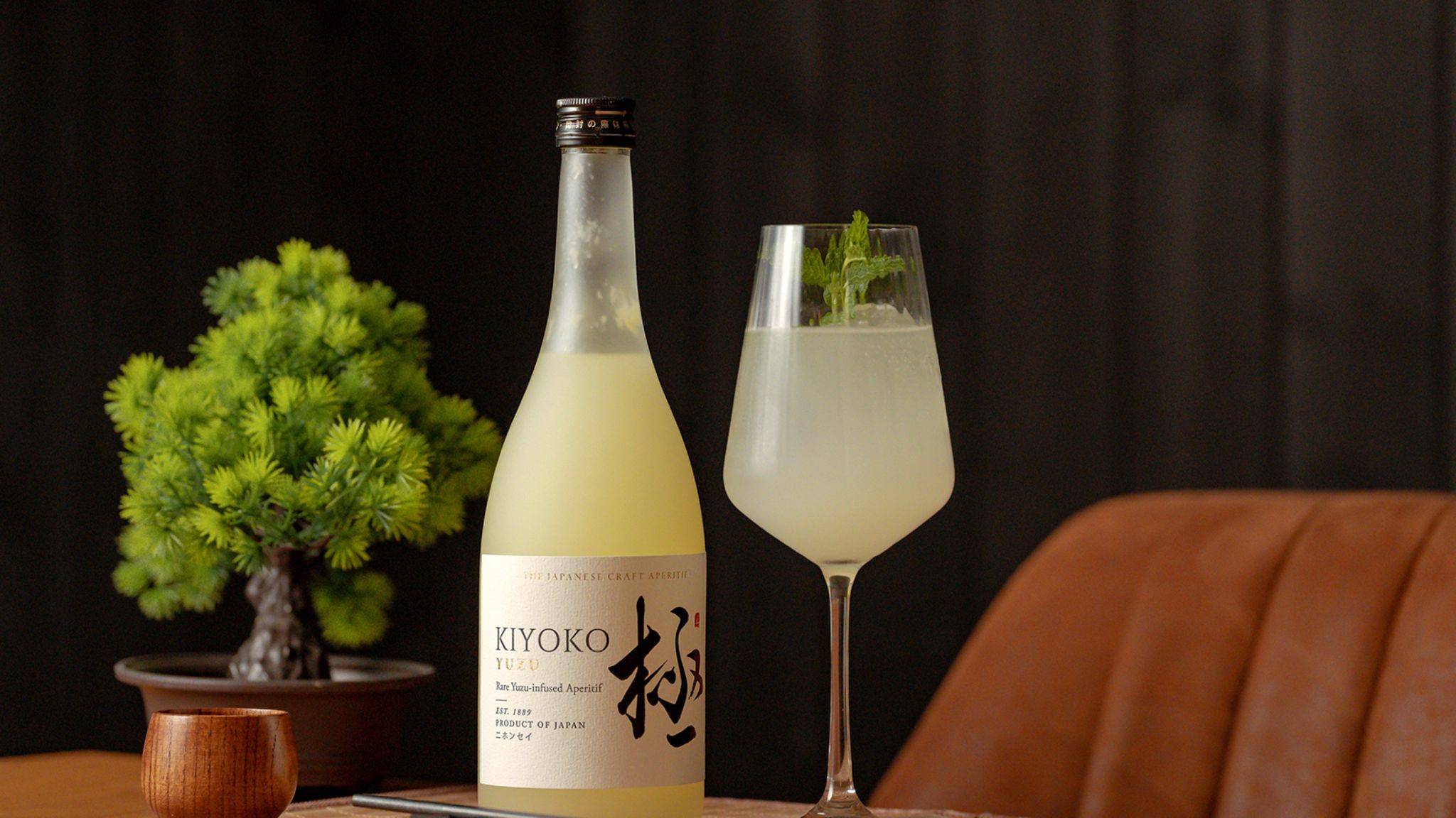 Aperol-Spritz Alternative: Glas und Flasche Yuzu auf dem Tisch