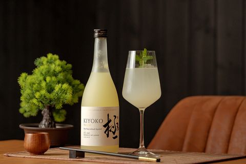 Aperol-Spritz Alternative: Glas und Flasche Yuzu auf dem Tisch