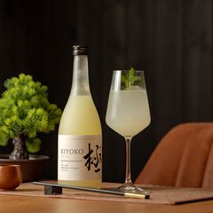 Aperol-Spritz Alternative: Glas und Flasche Yuzu auf dem Tisch