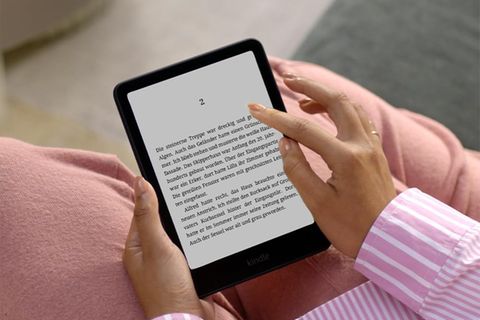 Eine Frau hält einen Kindle Paperwhite. Der Ebook-Reader gewann gerade bei Stiftung Warentest