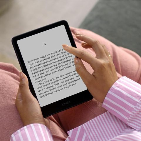Eine Frau hält einen Kindle Paperwhite. Der Ebook-Reader gewann gerade bei Stiftung Warentest
