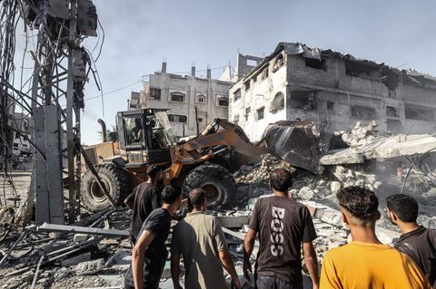 Gazakrieg: Palästinenser suchen in den Trümmern einer durch israelische Bomben zerstörten Tankstelle nach Opfern