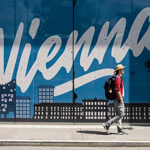 Ein Mann läuft an einem Vienna Schriftzug vorbei