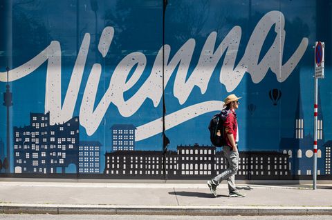 Ein Mann läuft an einem Vienna Schriftzug vorbei