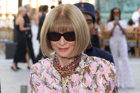 Anna Wintour mit Sonnenbrille, Pagenschnitt und buntem Kleid