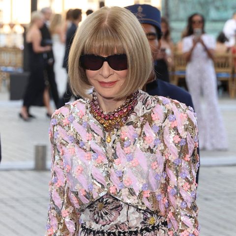 Anna Wintour mit Sonnenbrille, Pagenschnitt und buntem Kleid