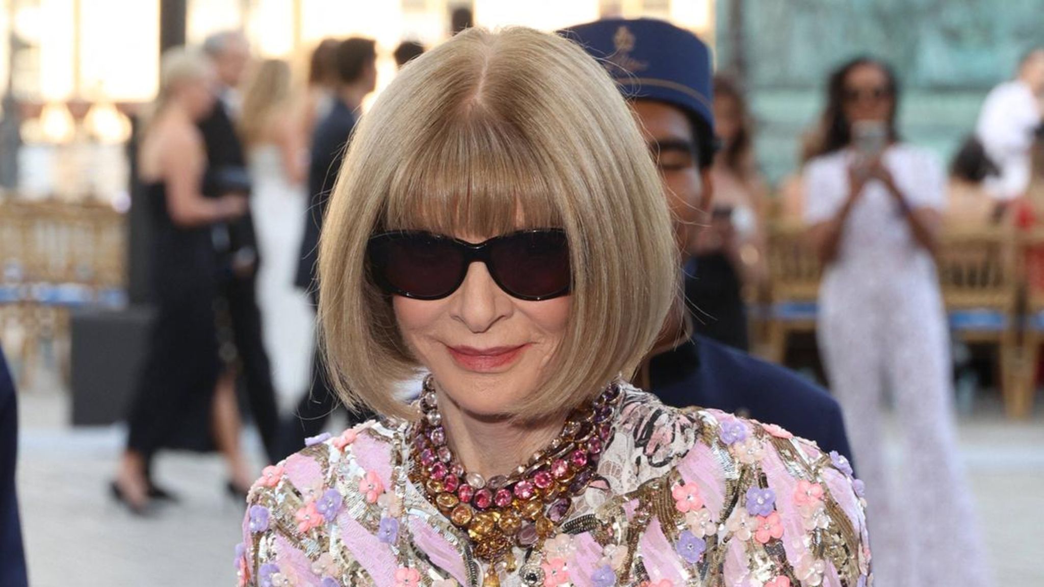 Anna Wintour mit Sonnenbrille, Pagenschnitt und buntem Kleid