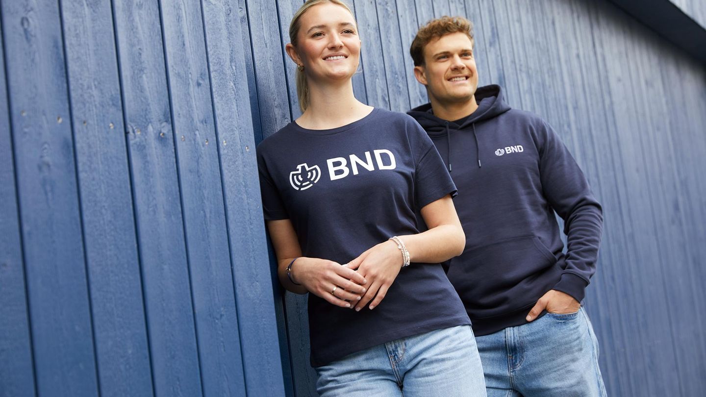 In einem Werbefoto trägt eine Frau ein BND-Shirt, ein Mann einen BND-Hoodie